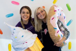 Morgan and Volta posing in front of the sprinkled donut wall