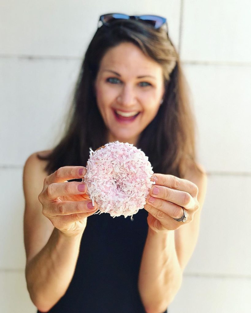 The Baker Mama holding the infamous Pink Boa donut from Top Pot